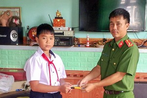 六年級學生高志源（左）將所拾到的款項轉交予當地公安派出所代表，以託尋找失主歸還。（圖源：慶福）