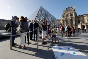 遊客在盧浮宮博物館門口排長隊等待。（圖源：AFP）