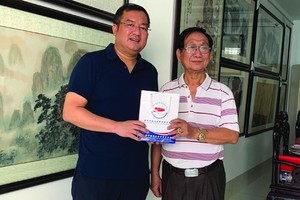 趙騫會長（左）向張漢明畫家贈送禮物。
