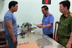 黎明山（左）站立著聽取執法警員宣讀逮捕令。（圖源：BPN）