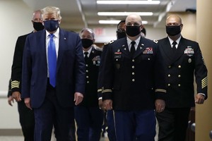 美國總統特朗普(左一)在訪問一家軍事醫療中心時，被拍攝到戴著口罩。（圖源：AP）