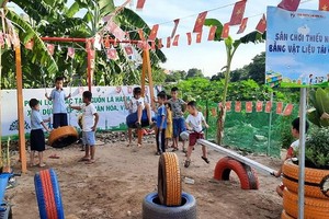 偏遠區孩子在用再造物料做的兒童遊樂園玩耍。