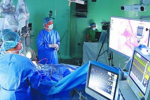 115人民醫院醫生應用機器人為病人施腦腫瘤手術。