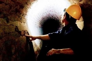 工人檢查以準備修復市中心區陳舊排水涵洞系統。