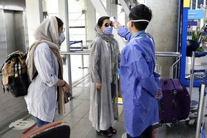 在伊朗德黑蘭的機場，工作人員為民眾量度體溫。（圖源：AP）