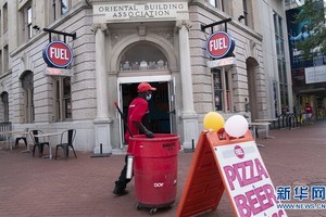  7月17日，在美國首都華盛頓，一名清潔工經過一家重新開業的餐館。（圖源：新華社）