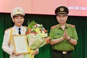 公安部長蘇霖大將（右）受國家主席的委託，向市公安廳副廳長丁清閑（左）頒授晉升少將警銜《決定》。（圖源：市公安廳）