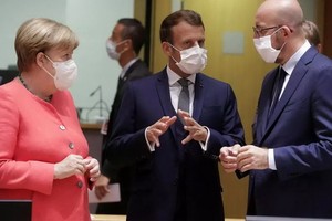 法國總統馬克龍（中）與德國總理兼歐盟輪值主席默克爾（左）在歐盟峰會進行談判。（圖源：路透社）