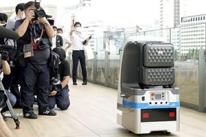 當地時間7月27日，東京高輪新車站開展機器人消毒實證試驗。（圖源：共同社）