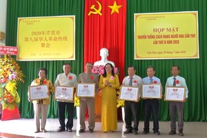 芹苴市越南祖國陣線委員會副主席阮翠姮（中）向華人同胞集體典範代表頒發獎狀。（圖源：芹苴電視台）