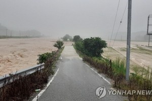 8月2日上午，位於忠清北道忠州市的永德川堤防遭暴雨襲擊垮塌，周圍的公路和農田被淹。（圖源：韓聯社）