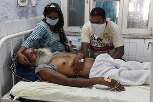 一名誤喝假酒中毒的老人及時獲送醫院搶救後暫時脫離險境。（圖源：AFP）