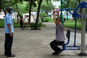 防疫工作人員提醒一名在黎文八公園鍛煉身體的市民應佩戴口罩。（圖源：何安）