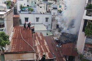 消防隊員爬上隔壁鐵皮屋頂展開滅火行動。（圖源：消防警察提供）