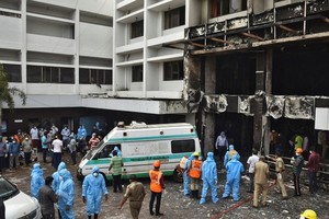 救援人員在印度發生火警的酒店搜救。（圖源：路透社）