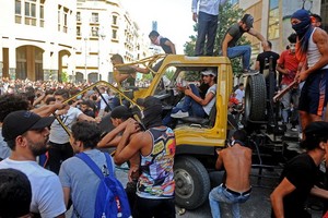 在黎巴嫩首都貝魯特，示威者破壞一輛吊車。（圖源：新華社）