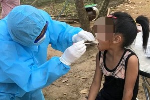 防疫工作人員向一名女童進行咽喉拭子取樣測試。（圖源：進一）