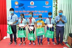 滀臻省越南祖國陣線委員會代表向落葉劑受害者的學生頒贈“梁定古”助學金和禮物。（圖源：忠孝）