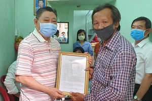 杭慰瑤先生(左)將溫情屋修建證書轉交黃富家庭。