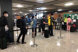 從美國撤回的我國公民在機場排隊等候辦理登機手續。（圖源：外交部）