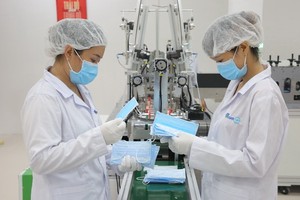 Ecom Net公司技術員正檢查出廠醫用口罩的質量。（圖源：Ecom Net）