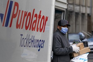 疫情期間，一名快遞服務人員為客戶上門送貨。（圖源：加通社）