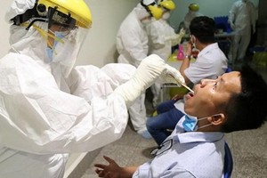 近距離接觸白喉病患者易被傳染。圖為醫護人員向白喉疑似患者進行喉嚨拭子取樣測試。（圖源：秋莊）