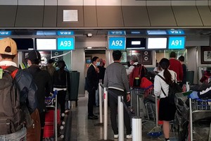 從南非撤回的我國公民在OR Tambo國際機場排隊等候辦理登機手續。（圖源：越通社）