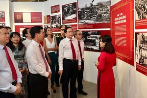中央宣教部長武文賞及越南祖國陣線中央委員會主席陳清敏與各界人士一同觀賞展會資料圖。（圖源：安黎）