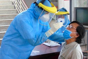 越南連續３天無境內確診。圖為醫護人員向新冠肺炎疑似患者進行鼻拭子取樣測試。（示意圖源：田升）