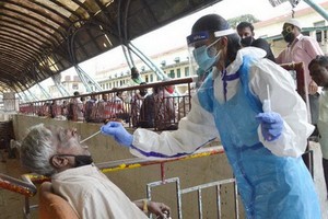 9月1日，在印度班加羅爾，醫務人員為市場商販進行新冠病毒檢測取樣。（圖源：新華社）