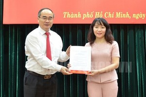 市財政廳廳長范氏紅霞（右）從市委書記阮善仁手中接過人事委任《決定》。（圖源：市黨部新聞網）