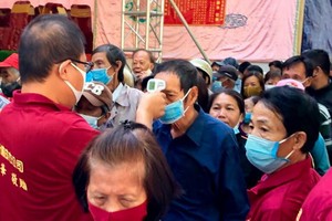 前來參加法會者均獲該會館工作人員測量體溫。