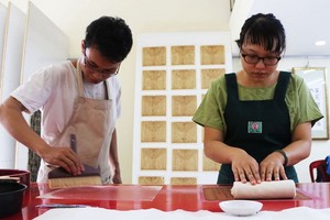 裴進福與佩泉正在複製漢喃書籍。