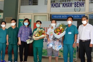 峴港市最後新冠病例康復者（右三）出院前同醫護人員合照。（圖源：慶紅）