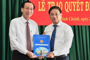 新任平政縣人委會主席陶嘉旺（右）從市人委會常務副主席黎清廉手中接過人事委任《決定》。（圖源：越勇）