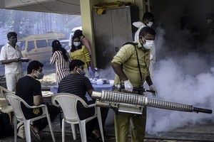 9月28日，一名工作人員在印度孟買一處新冠隔離中心進行滅蚊工作。（圖源：新華社）