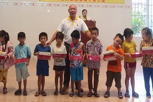 芽莊廣東會館理事長鄭成龍給小朋友派發月餅。