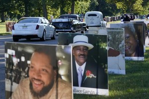 在美國底特律的貝爾島公園一隊車輛駛過新冠逝者的照片。（圖源：互聯網）