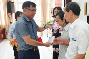 郡越南祖國陣線委員會副主席陳南德向高齡長者贈送禮物。