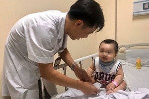 醫生在為一名感染手足口病的小童查體。（圖源：海吳）