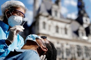 巴黎有醫護人員為民眾取樣本做病毒檢測。（圖源：路透社）