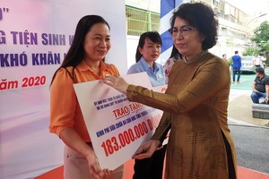 市越南祖國陣線委員會主席蘇氏碧珠向各郡縣頒贈建設溫情屋、情義屋的經費。