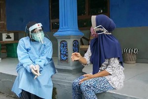 一名印尼紅十字會的志願者為一位受疫情影響的當地市民提供心理救助。