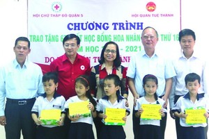 盧耀南理事長(右二)與本市、第五郡領導向五胞胎兄弟姐妹頒發獎學金。