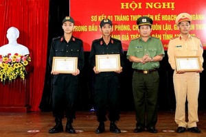 安江省公安廳廳長丁文處大校（右二）向3 名英勇營救遇險船員的水路警察頒贈獎狀。