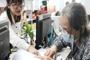 范氏絨（左）向民眾解釋社保結算手續。