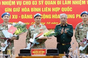 國防部副部長阮志詠上將（右二）向前往南蘇丹與中非共和國參與聯合國維和行動的軍官頒授國家主席《決定》並贈送鮮花祝賀。（圖源：VGP）