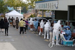 韓國市政府工作人員排隊等候接受新冠病毒檢測。（圖源：韓聯社）