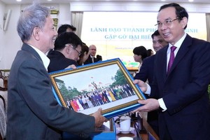 黨中央書記、市委書記阮文年（右）向僑胞贈送紀念品。